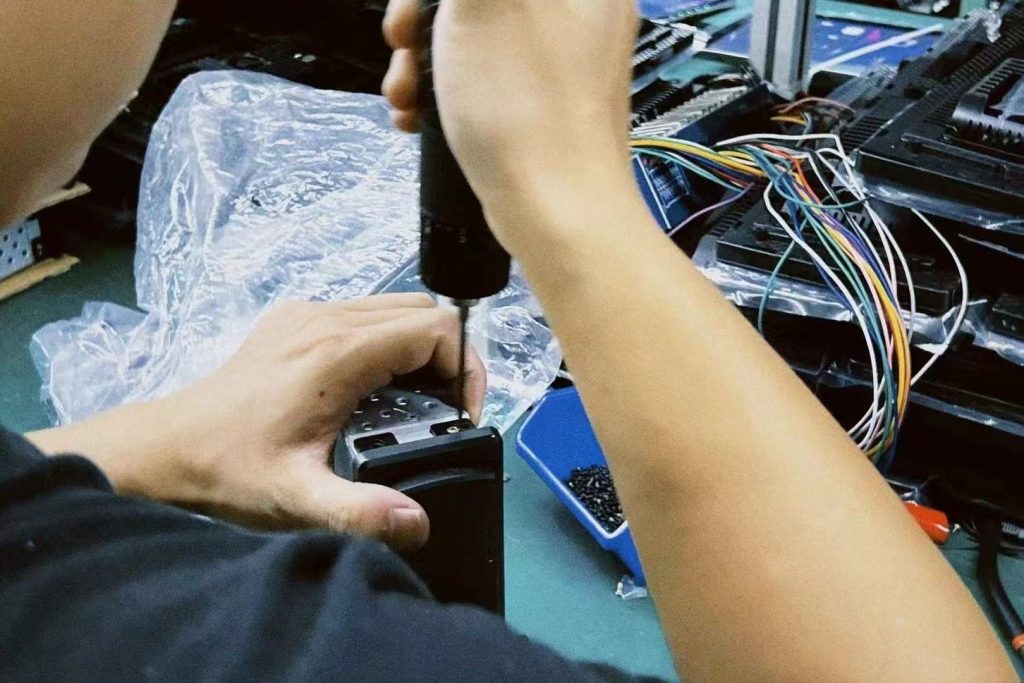 Técnico a testar em bancada um painel digital específico do veículo durante a revisão de garantia